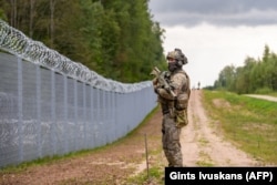 Сотрудник Государственной пограничной охраны на границе Латвии и Беларуси недалеко от Криванды, Восточная Латвия, фото AFP, 8 августа 2023 года